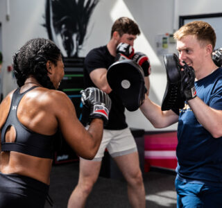 group_ex_boxing boxercise class, female user hitting the pads