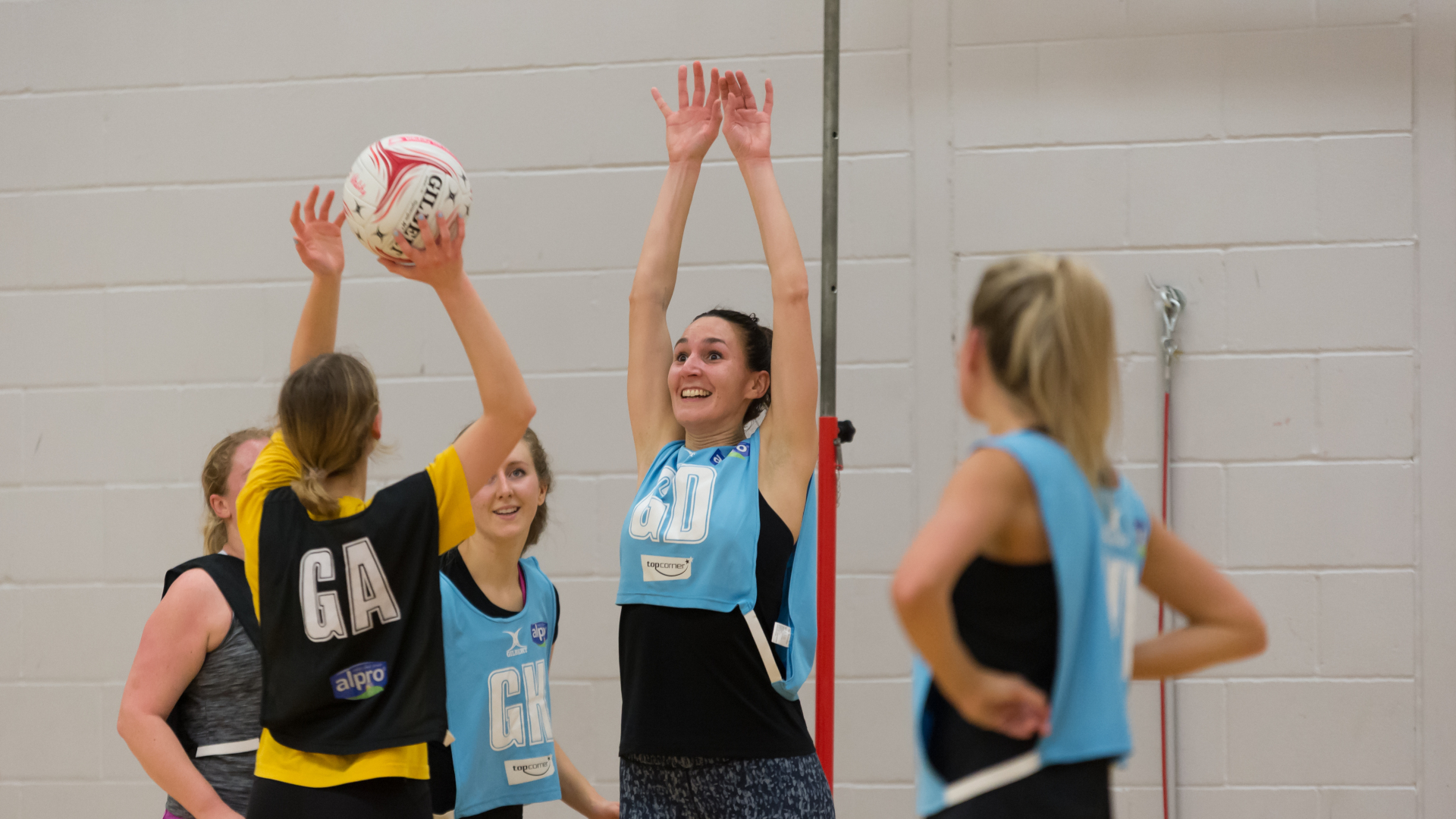 240118 – 007 two team playing netball, one team is about to shoot while the other attempts to block